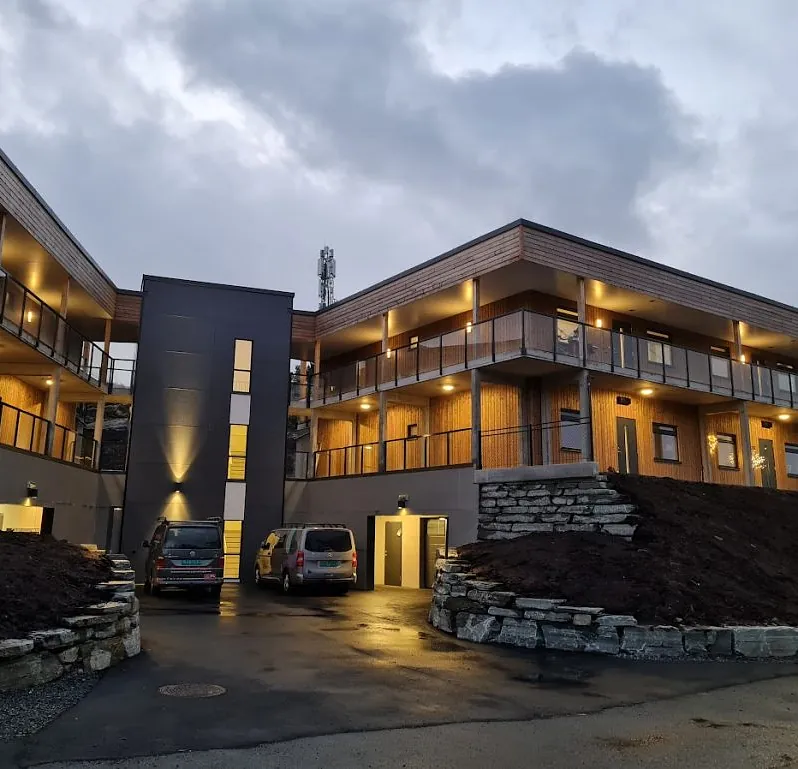 Moderne bygg med opplyste balkonger og glassrekkverk på begge sider.
